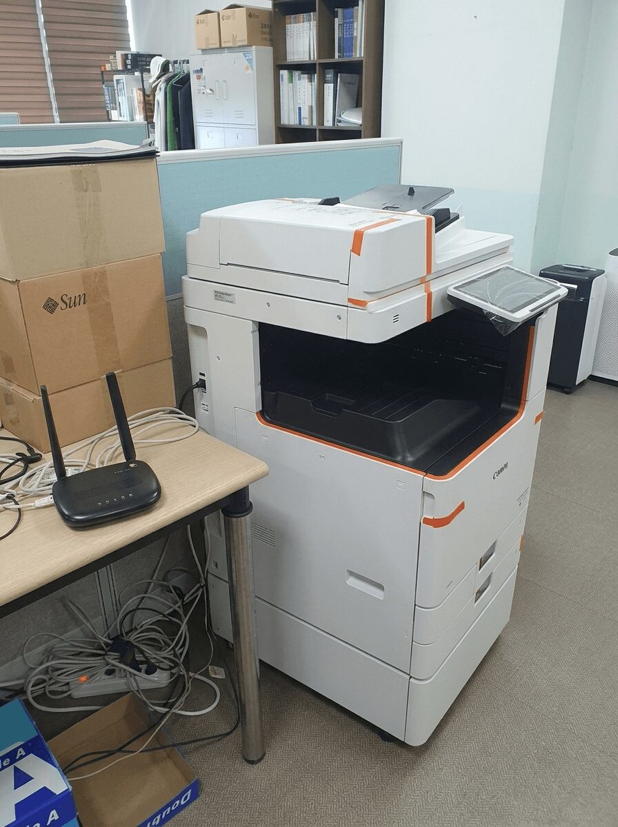 칸막이 사무실에 설치된 캐논 C3922 측면과 옆 책상의 라우터 구성