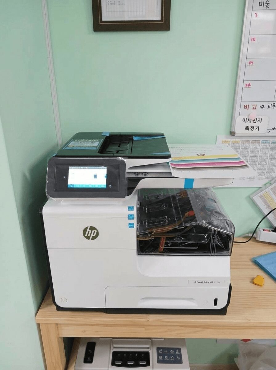 민트색 유치원 교무실 책상 위에 설치된 HP X477 복합기 정면 전경