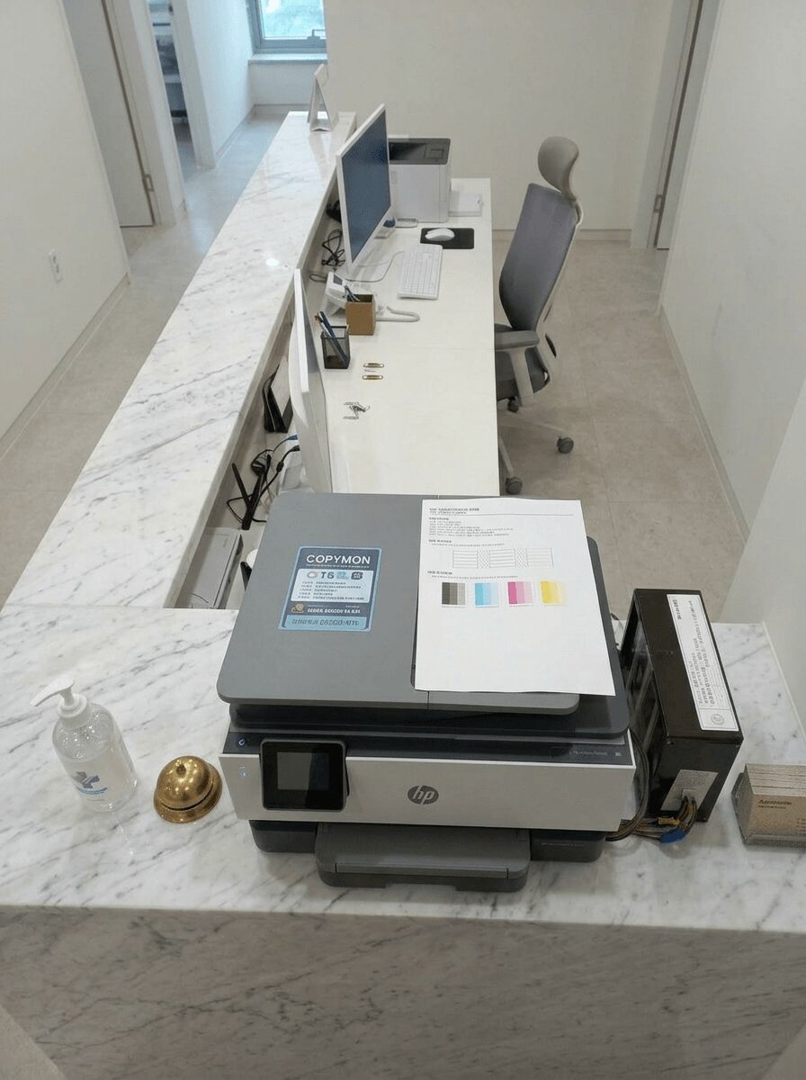 카피몬 스티커가 부착된 HP9010 복합기와 위에서 내려다본 병원 사무 공간 전경
